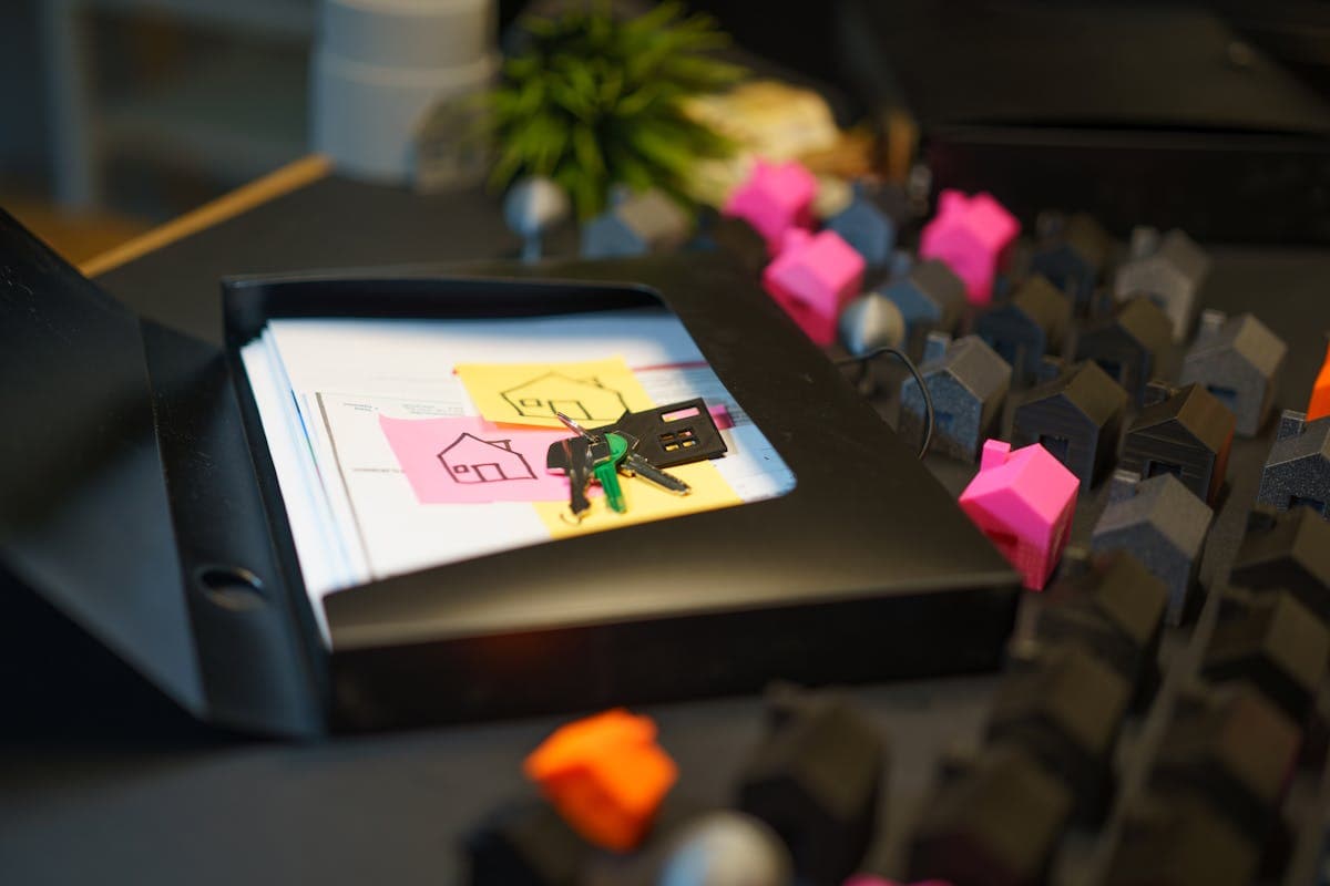 Real estate closing documents with keys and a house model